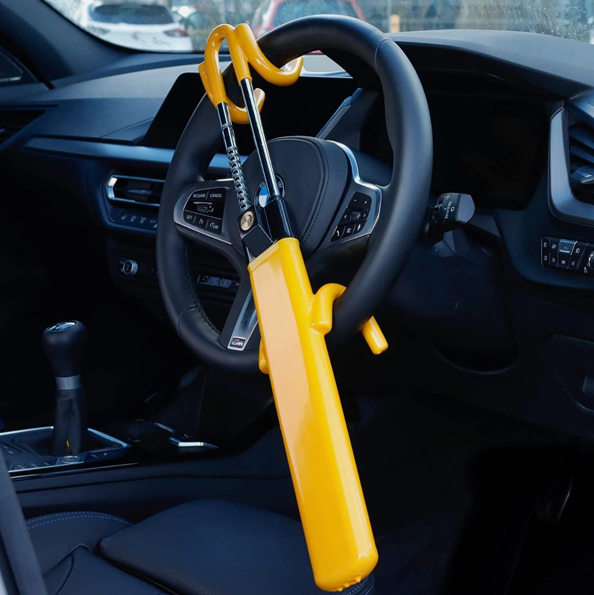 Yellow Heavy-Duty Twin Bar Anti-Theft Steering Wheel Lock on a steering wheel inside a vehicle
