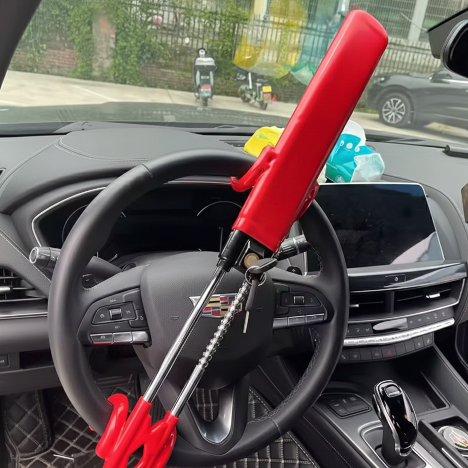 Red Heavy-Duty Twin Bar Anti-Theft Steering Wheel Lock on a steering wheel inside a vehicle with a blurred background