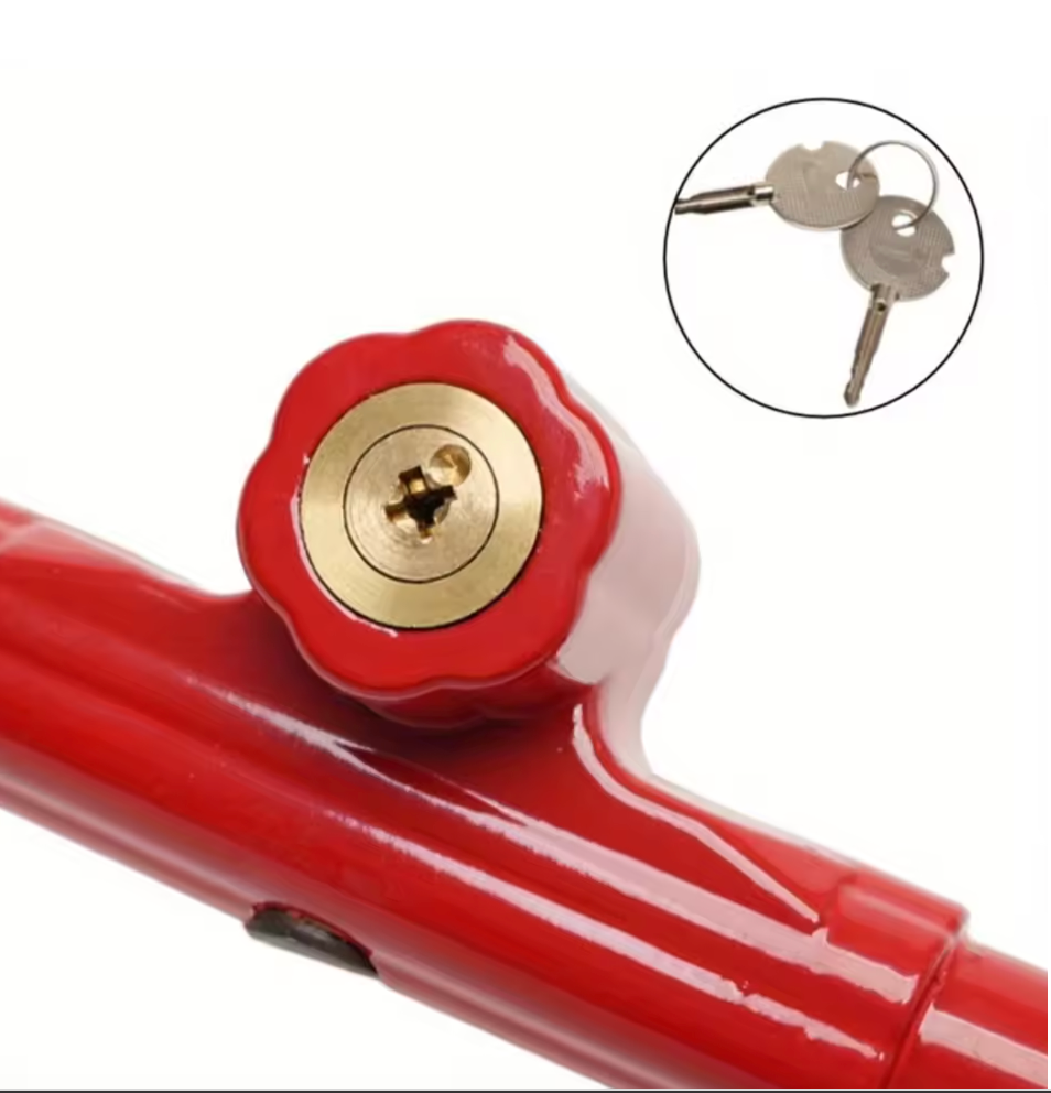 Close up of red lock with gold cylindrical mechanism and two keys of the steering wheel to brake pedal lock inset on a white background